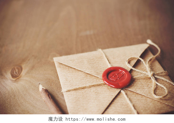 木质背景上一个密封的情书情书和铅笔